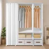 A white, multi-tiered wardrobe with hanging clothes, folded fabrics, and storage bins, partially covered by a white curtain. Náhľad obrázku produktu