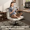 A woman is sitting on a chair reading a magazine in a home office setting. Produktbild-Vorschau