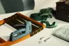 A staple gun is shown on a wooden frame with green straps, along with other crafting supplies. Podgląd zdjęcia produktu