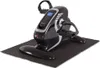 A black and silver mini exercise bike with a digital display, placed on a black anti-slip mat. Produktbild-Vorschau