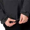A close-up shot of a person adjusting the drawstring on a black jacket. Náhľad obrázku produktu
