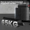 A stack of weight plates and a weight bench in a gym-like setting. Náhľad obrázku produktu
