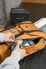 A person is putting a camera into an orange backpack. Náhled obrázku produktu