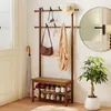 An entryway with a coat rack, shoe bench, umbrella, and a plant. Produktbild-Vorschau