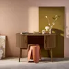 A wooden desk with a stool in a room with pink and olive green walls. Produktbild-Vorschau