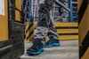 A person wearing work pants and safety shoes walks in a warehouse. Náhľad obrázku produktu