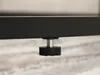 A close-up of a furniture foot with an adjustable screw mechanism on a textured surface. Podgląd zdjęcia produktu