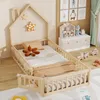 A child's bed with a house-shaped frame and safety rails, set in a bedroom with toys and decor. Náhľad obrázku produktu