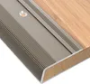 A close-up view of a metal stair nosing profile installed on a wooden surface. Anteprima dell’immagine prodotto