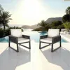 Two chairs are placed on a patio next to an infinity pool with a scenic ocean and mountain view. Voir les images du produit