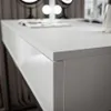 A close-up view of the corner of a white, high-gloss vanity table with a drawer. Náhľad obrázku produktu