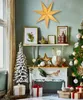 A festive Christmas display with a large star decoration, a decorated Christmas tree, and various festive ornaments and gifts. Voir les images du produit