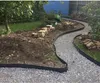 A garden path being constructed with gravel and black edging, with bricks stacked nearby. Podgląd zdjęcia produktu