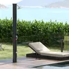 An outdoor shower and lounge chair are set up on a wooden deck overlooking the ocean. Produktbild-Vorschau