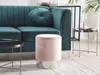 A pink velvet pouf sits in front of a teal sofa in a living room setting. Náhled obrázku produktu