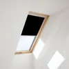 A skylight window with a black blackout blind partially lowered. Produktbild-Vorschau