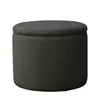 A studio shot of a round, upholstered storage ottoman. Produktbild-Vorschau