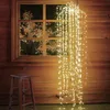 A string of warm white fairy lights cascades down in front of a wooden wall and a window. Produktbild-Vorschau