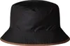 A black bucket hat with a brown trim is shown against a white background. Produktbild-Vorschau