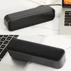 Two images of a black mini USB speaker placed on a wooden surface next to a laptop. Produktbild-Vorschau