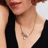 A close-up shot of a person wearing a necklace with charms. Podgląd zdjęcia produktu