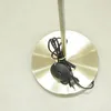 A close-up view of the base of a floor lamp, showing the power cord, foot switch, and plug. Produktbild-Vorschau