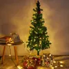 A decorated Christmas tree with presents underneath, illuminated by string lights. Produktbild-Vorschau