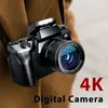 A digital camera is held up against a brown fabric background, with text overlays indicating its features. Produktbild-Vorschau