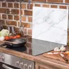 A kitchen scene with a stovetop, cooking utensils, and ingredients. Anteprima dell’immagine prodotto