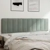 A padded headboard over a bed with bedding. Produktbild-Vorschau