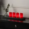 Four red LED candles and a vase with eucalyptus are placed on a black tray on a black dresser. Produktbild-Vorschau