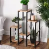A multi-tiered plant stand with various decorative items and plants, placed in a room setting. Anteprima dell’immagine prodotto
