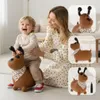 A mother and child playing with a bouncy dog toy indoors. Produktbild-Vorschau