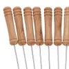A close-up view of the handles of several metal skewers with wooden handles. Produktbild-Vorschau