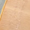 A close-up view of a wooden surface with some granular material on it. Produktbild-Vorschau