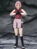 A full-body shot of an action figure of Sakura Haruno from Naruto Shippuden, standing with her hands clasped in front of her chest. Náhled obrázku produktu