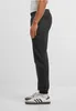 Side view of a person wearing black sweatpants and white sneakers. Produktbild-Vorschau