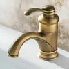 A close-up shot of a retro-style brass faucet on a white sink with a marble-patterned wall in the background. Produktbild-Vorschau