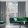 A living room scene with a green sofa, grey curtains, and a view of a city through the window. Produktbild-Vorschau