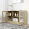 A wooden sideboard with glass doors, displaying various items inside, placed on a rug in a room. Produktbild-Vorschau