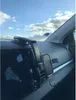 View of a car's dashboard with a phone mount attached, with the sky visible through the windshield. Anteprima dell’immagine prodotto