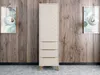 A tall, narrow wardrobe with a chevron pattern on the upper doors and three drawers below, set against a wood-paneled wall with two framed pictures and pendant lights on either side. Voir les images du produit