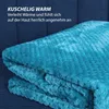 A folded teal blanket is shown on a dark blue textured surface, likely a sofa or couch. Náhľad obrázku produktu