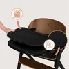 A hand is shown removing a black tray from a wooden high chair. There are circular insets highlighting features. Voir les images du produit