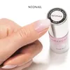 A hand is holding a nail polish bottle, with a painted nail in focus. Podgląd zdjęcia produktu