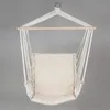 A beige cotton hanging chair with a cushion, suspended by white ropes from a wooden bar. Produktbild-Vorschau