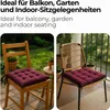 A collage of two images showing burgundy seat cushions on chairs, one wooden and one rattan, in outdoor settings. Voir les images du produit
