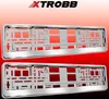 Two chrome license plate frames are shown against a red and white gradient background, with a brand logo at the top. Produktbild-Vorschau