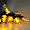 A close-up of a string of LED garden lights with clear bulbs and visible filaments. Anteprima dell’immagine prodotto