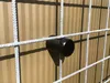 A close-up shot of a black plastic spacer attached to a white wire fence. Produktbild-Vorschau